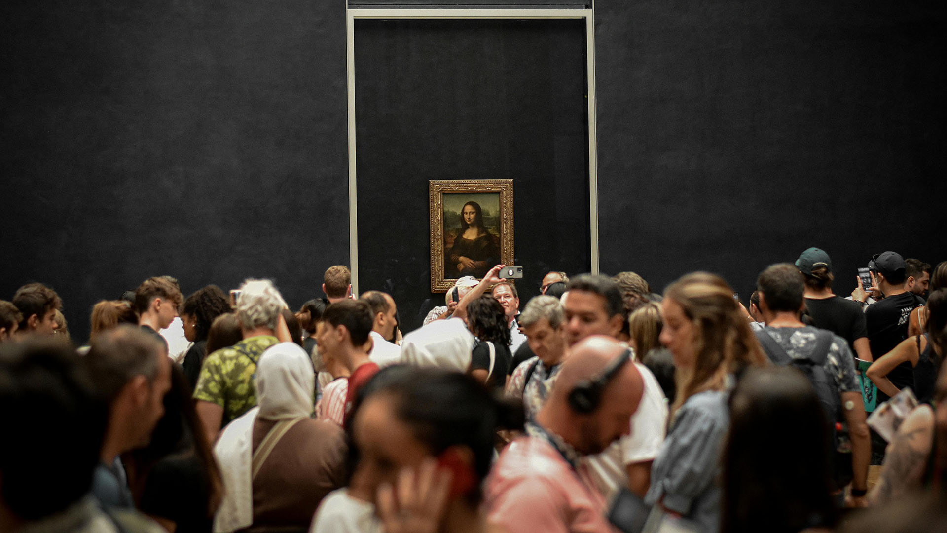 turisti che fotografano la Monnalisa di Leonardo da Vinci al museo del Louvre a Parigi, Francia