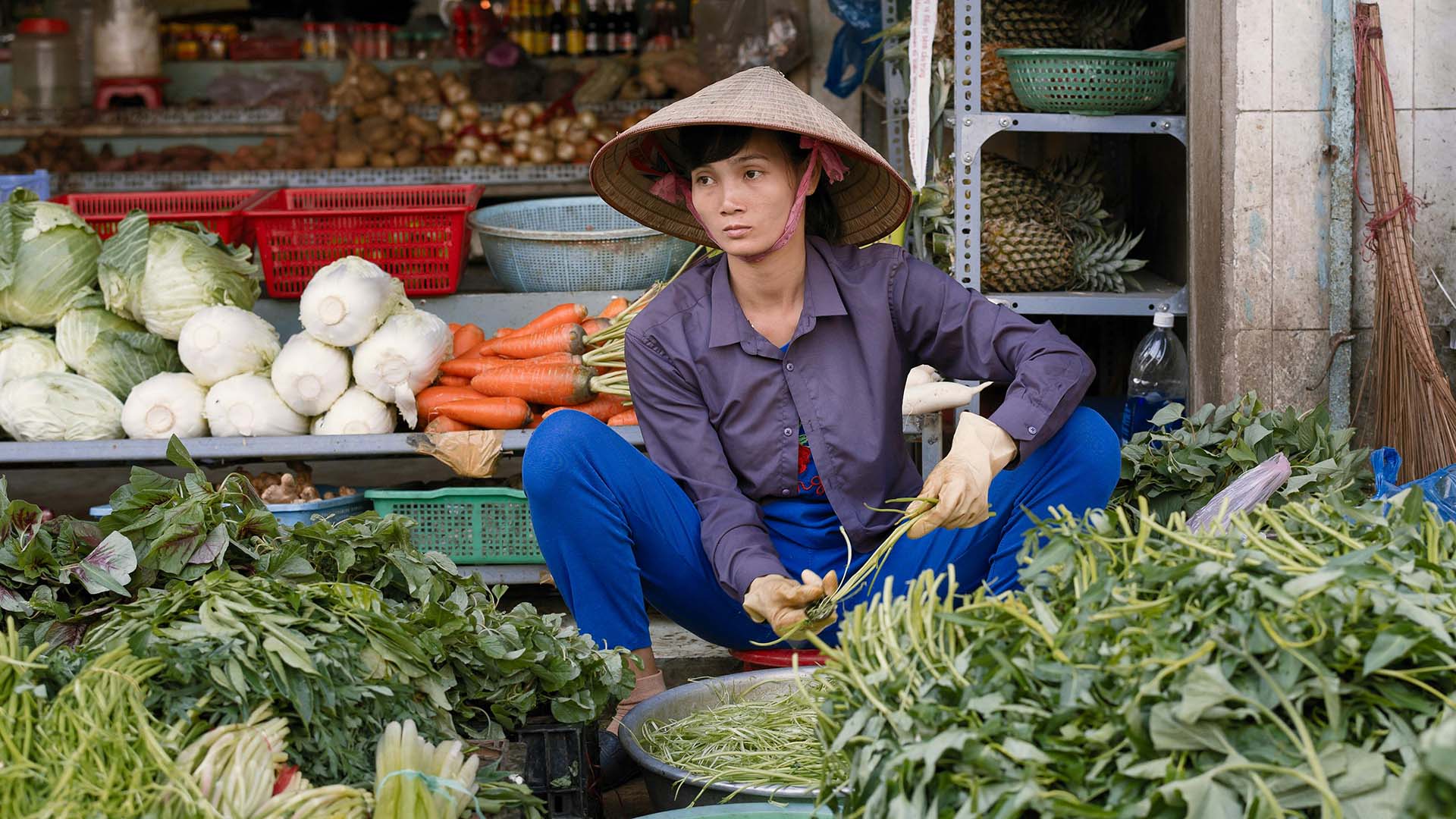 venditore di frutta e verdura con tipico copricapo vietnamita in bamboo