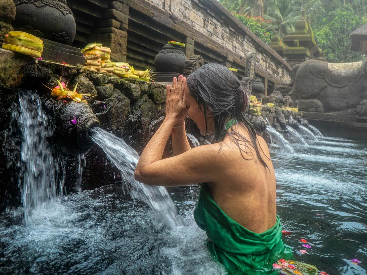 donna che si immerge nelle acque sacre del Tempio di Tirta Empul a Bali in Indonesia