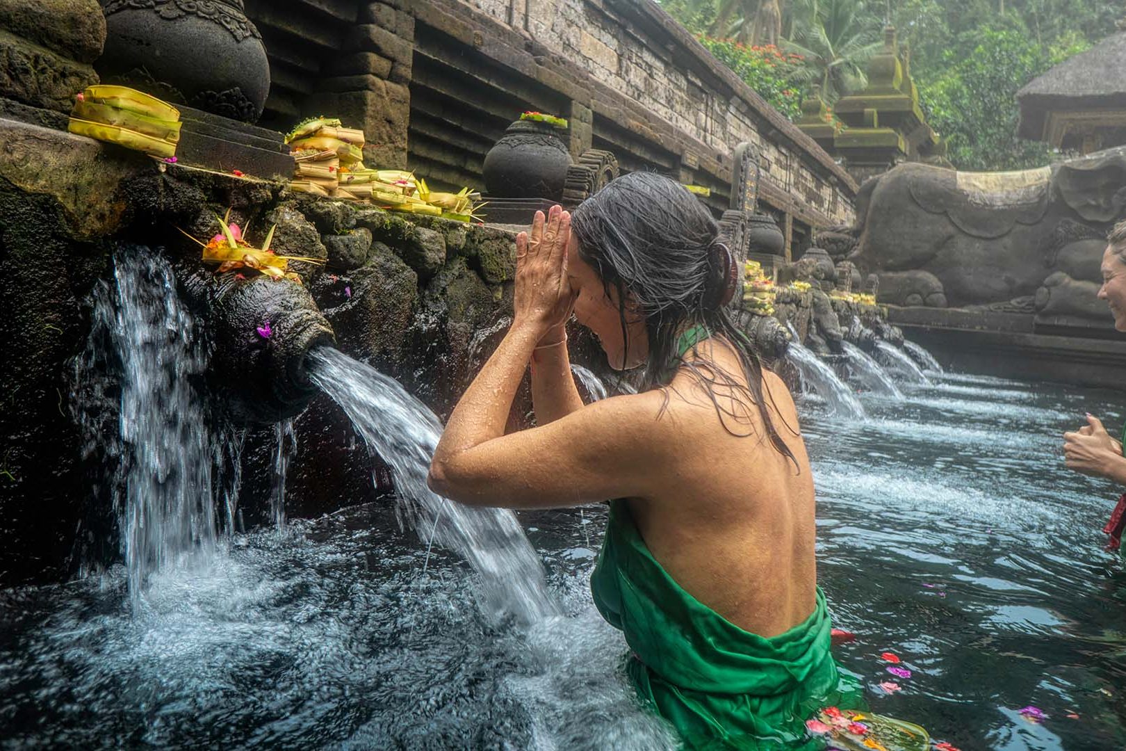 donna che si immerge nelle acque sacre del Tempio di Tirta Empul a Bali in Indonesia